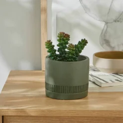 Plante verte artificielle et pot en ciment
